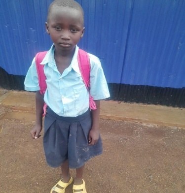 A sponsored pupil in a light blue school shirt with a pink backpack